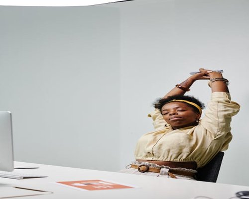 A person stretching their arms while sitting at an office desk